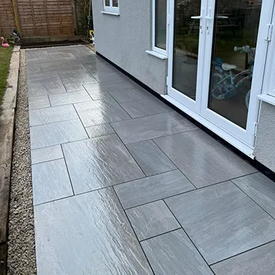 A patio with a stone walkway next to a house.